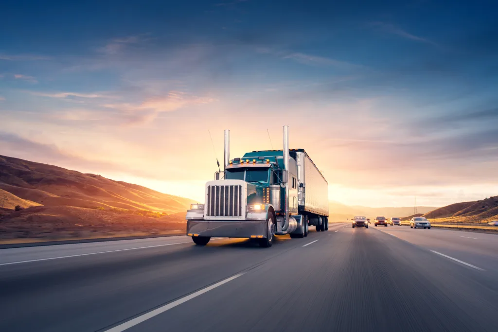 American style truck on freeway pulling load. Transportation theme. Road cars theme.
